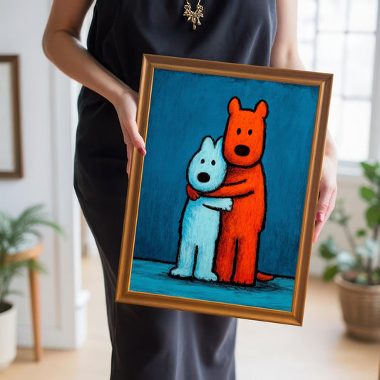 Woman in a black dress holding a small, gold-framed art print of two hugging dogs (one orange, one blue), showcasing the artwork and its frame.