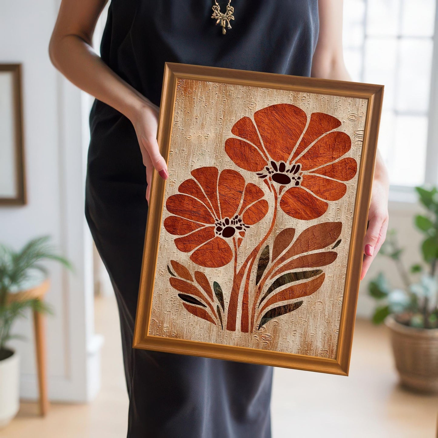 A woman in a black dress holds the orange flower art print in an Orange Wood Frame up close, showing the scale and detail of the artwork.