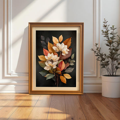 A framed art print featuring a bouquet of white flowers with yellow, orange, and red autumn leaves against a dark background. The print is in an Orange frame with a Mount (matting) and is leaning against a white wainscoted wall next to a potted plant, creating a cozy corner display.