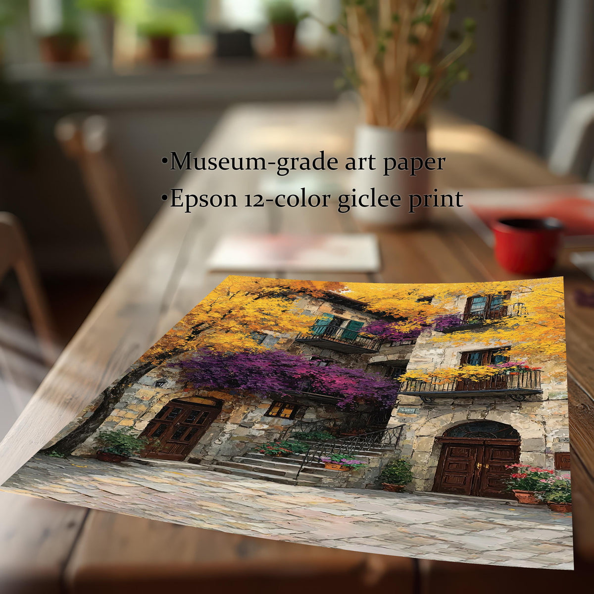 Close-up showing a rolled art print featuring a colorful stone building with yellow and purple flowers, lying on a wooden table. Text overlay highlights product quality: "Museum-grade art paper" and "Epson 12-color giclee print."