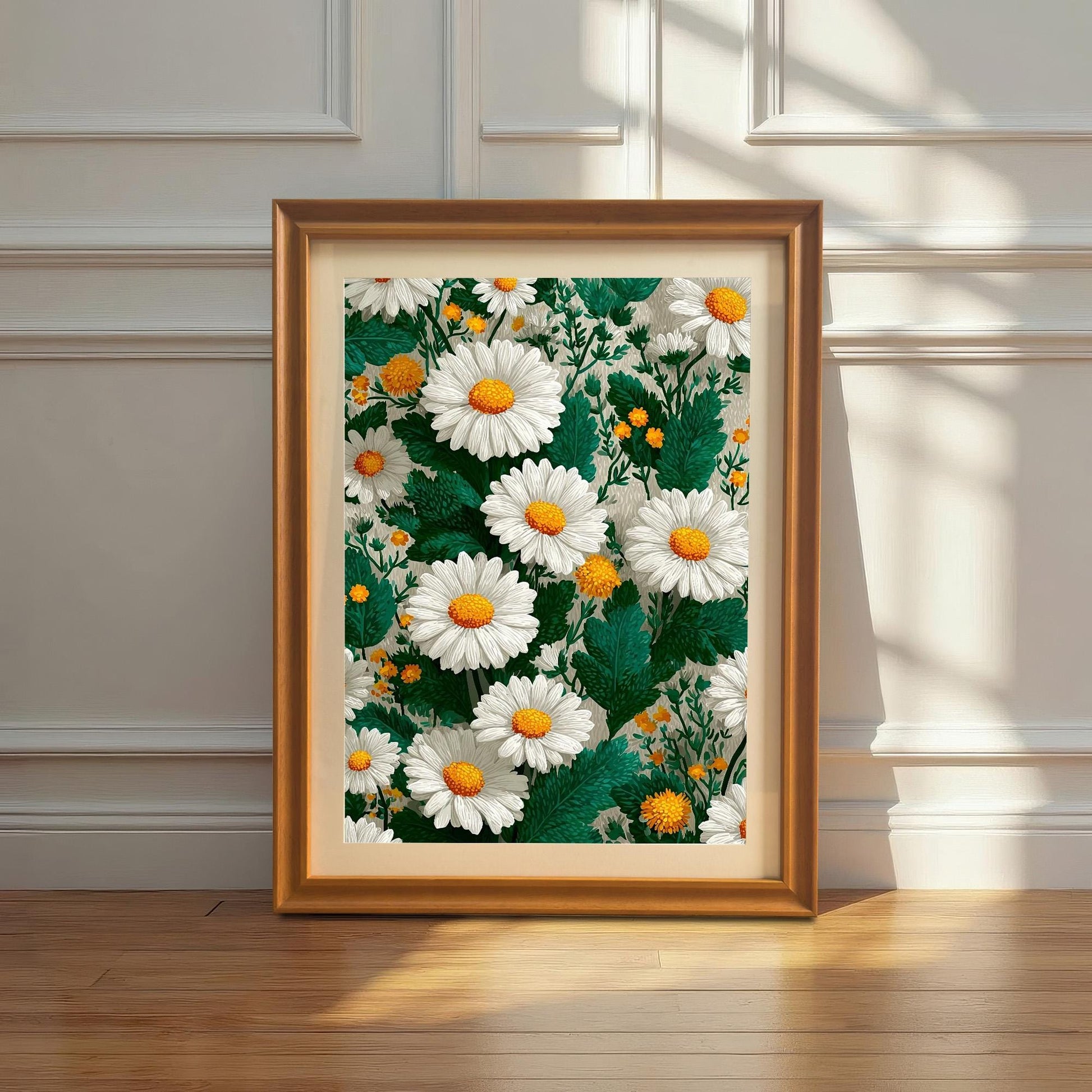 Framed art print with an orange/gold wood frame leaning against a white wainscoted wall. The painting is a vibrant, repeating pattern of white daisies with yellow centers.