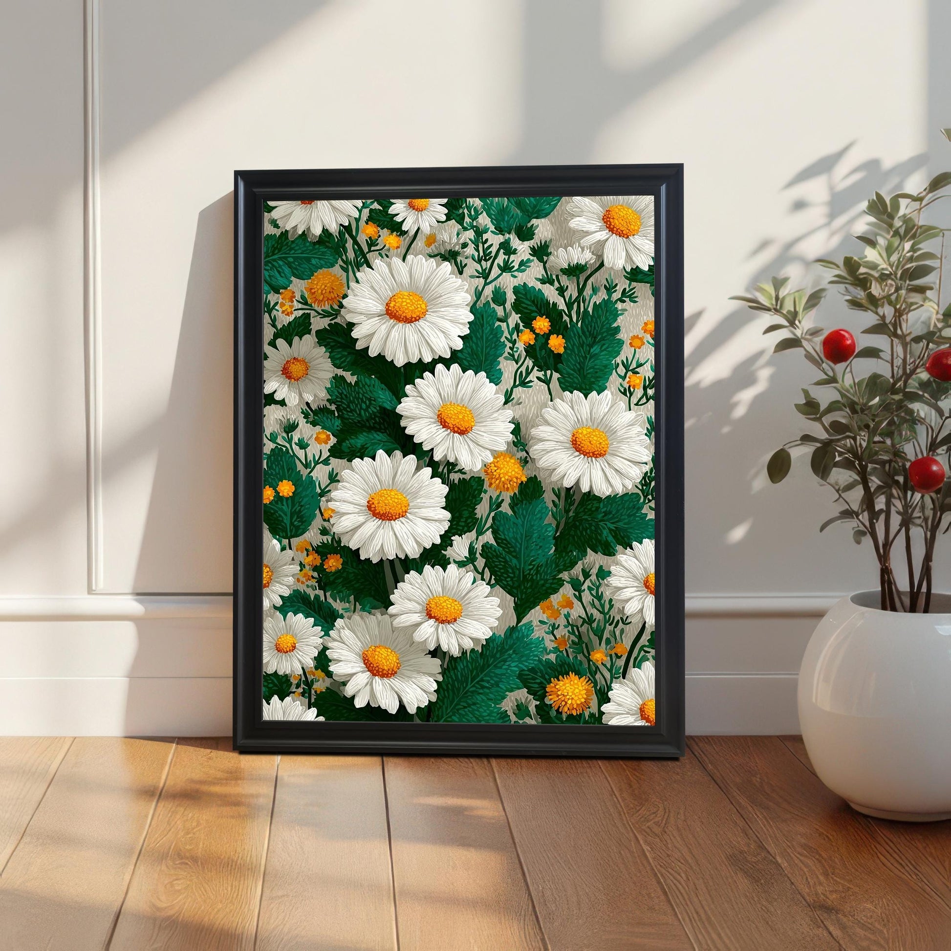 Framed daisy art print with a black wood frame leaning on a light wooden floor against a white wainscoted wall, next to a white vase with a plant.