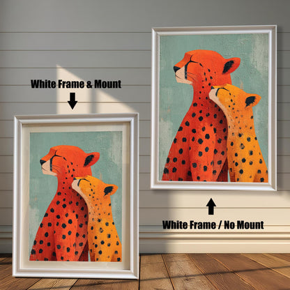 Two framed versions of the 'Cheetah Love' print against a wooden wall. On the left is the White Frame with a light mount/matting. On the right is the White Frame without a mount.