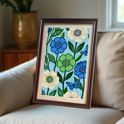 A dark brown Coffee framed art print featuring a pattern of blue, green, and cream flowers with blue butterflies on a light blue background. The print is propped up on a beige sofa.