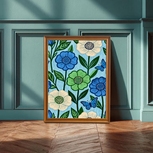 A gold-toned Orange framed art print featuring the blue and green floral pattern artwork, propped on a wooden floor against a paneled wall painted a deep teal color.