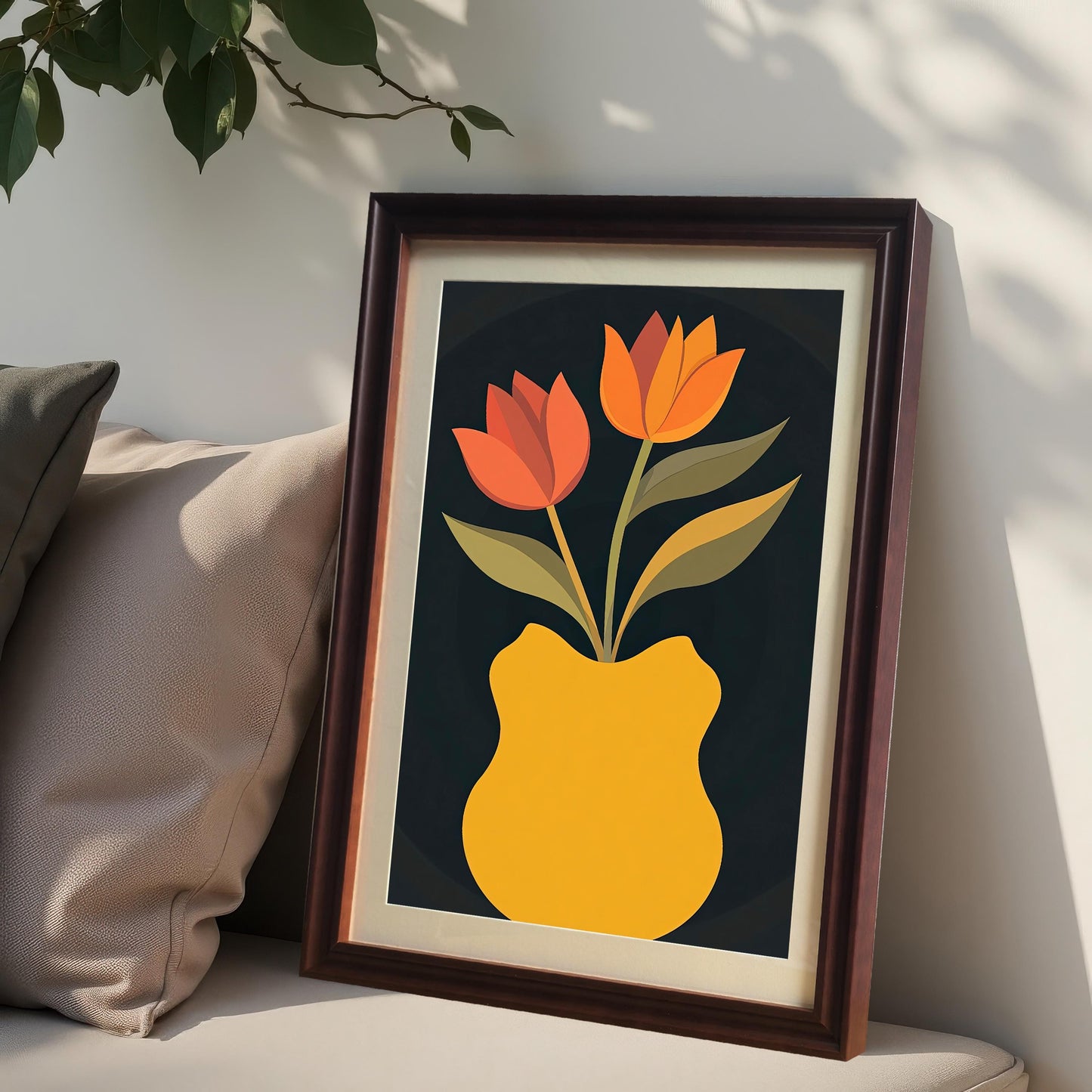 Coffee-colored framed art print with a light mount, featuring two orange and red tulips in a yellow vase. The print is leaning against a wall on an upholstered bench next to two pillows.
