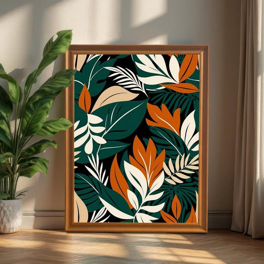 Large, tropical leaf art print in a Brown/Wood frame, propped up on a wooden floor next to a large potted houseplant in bright light.