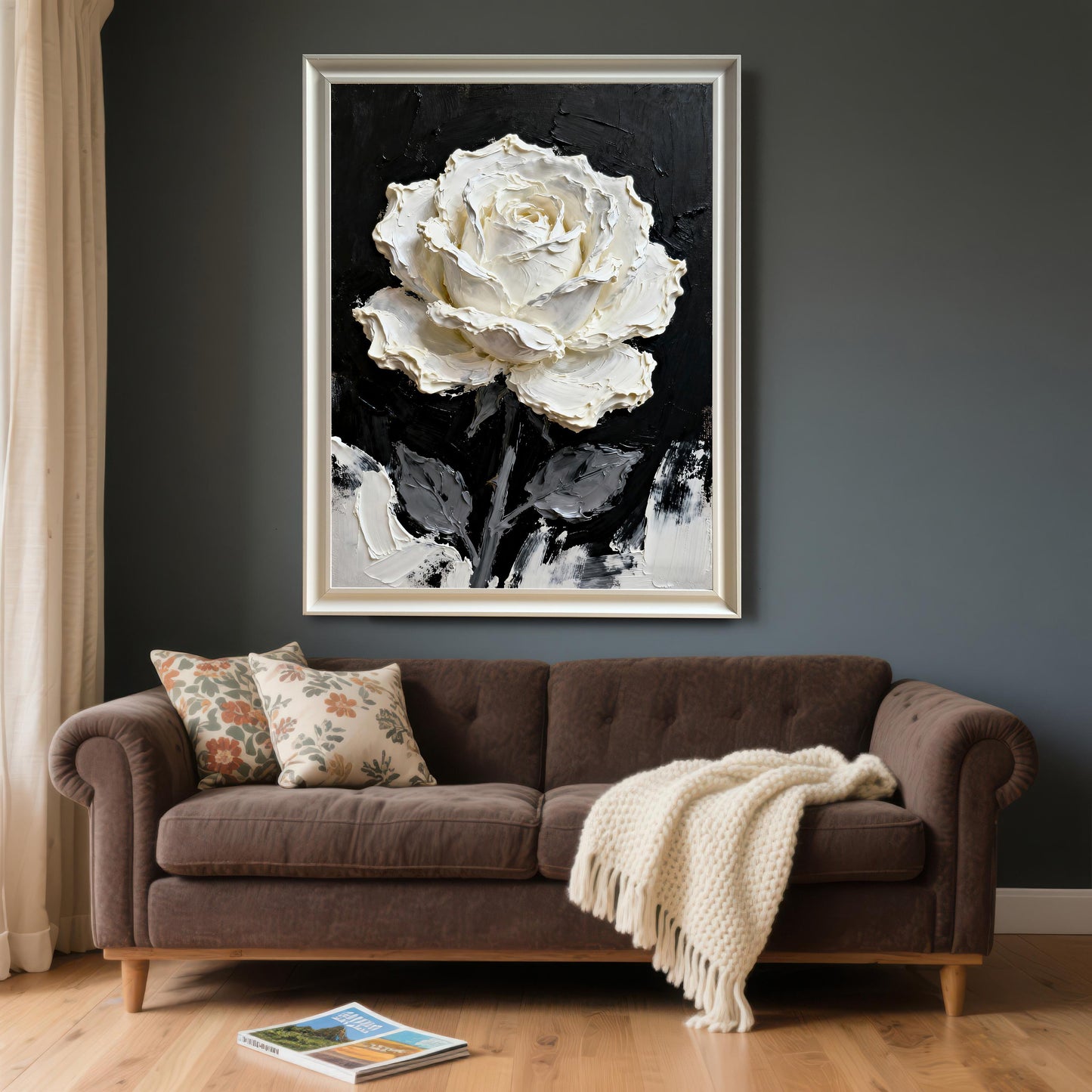 A very large framed print of the textured white rose painting with a White wood frame, hanging above a dark brown sofa in a modern room with dark gray walls and a light wood floor.