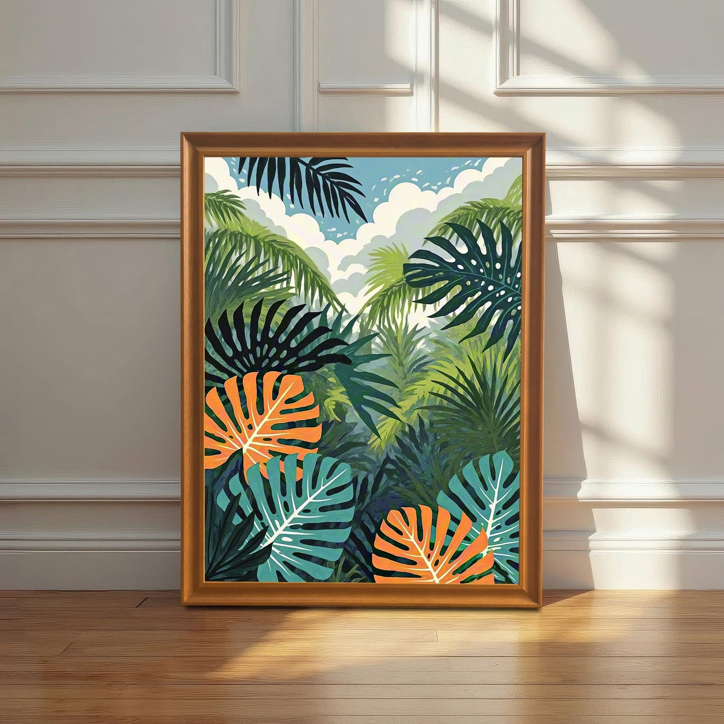 A vibrant, framed art print featuring a tropical jungle scene with green palm fronds, dark teal leaves, and bright orange-and-white monstera leaves, leaning against a white wainscoting wall on a hardwood floor, bathed in natural sunlight.
