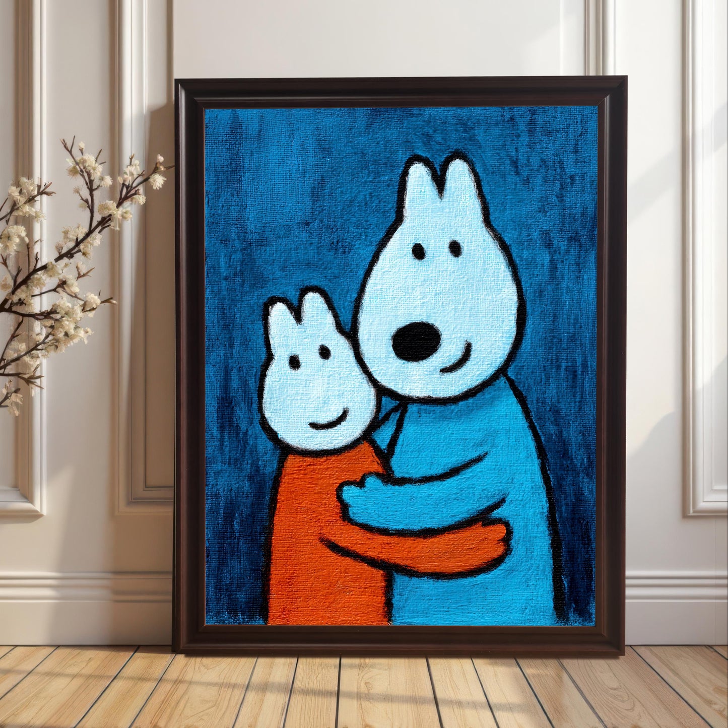 A framed art print in a Coffee-colored wood frame without a mount leaning against a wainscoted wall next to a branch of white blossoms, featuring the print of two hugging cartoon animals.