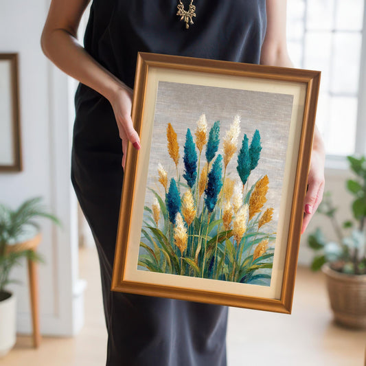A person holding the teal and gold coastal grass abstract art print in an Orange wood frame with a mat.
