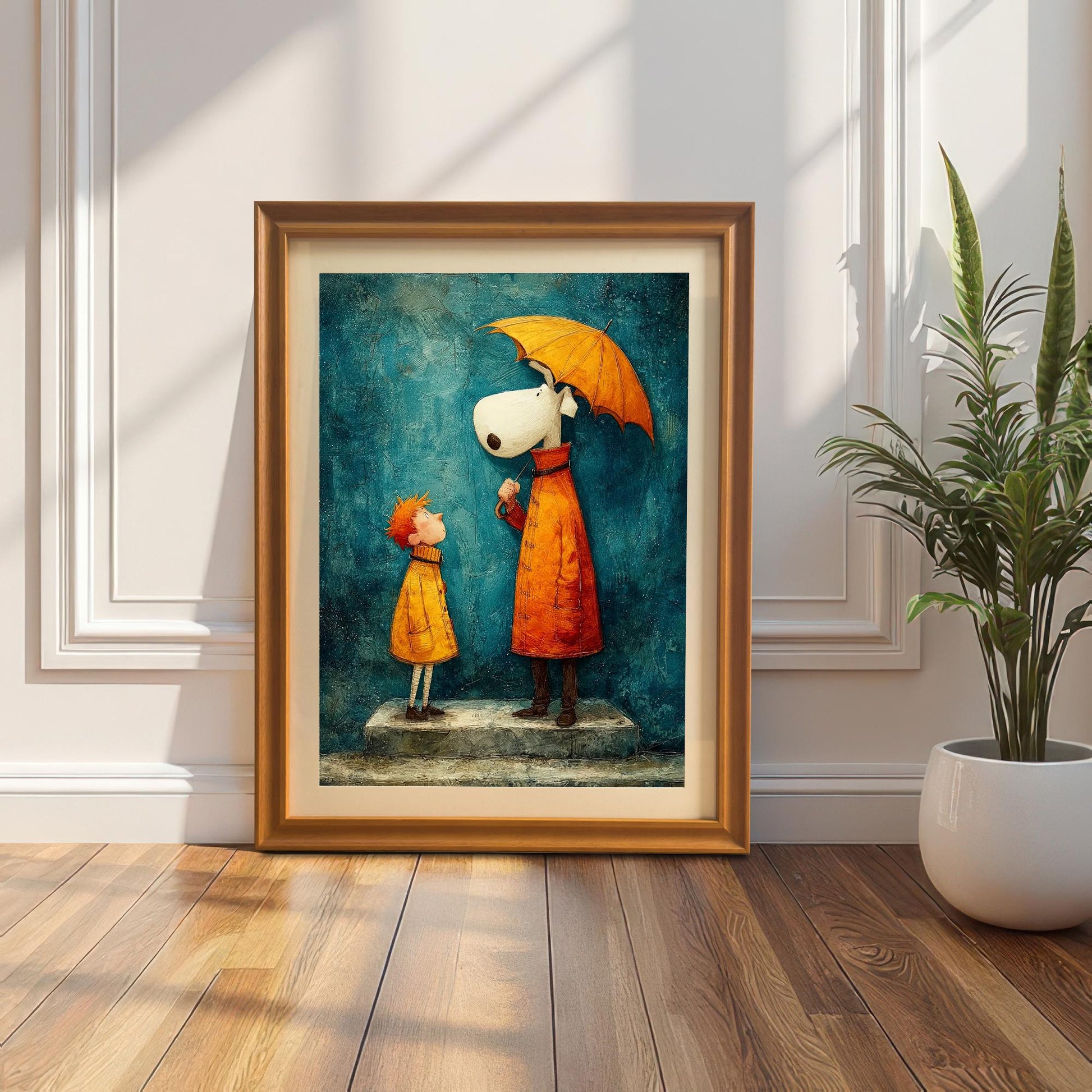 Whimsical framed art print in a gold/orange wood frame, leaning on the floor against a classic white wainscot wall, next to a potted snake plant.