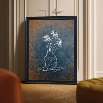 Framed chalk flower print in a black wooden frame leaning on a light hardwood floor against a beige door, with the focus on the artwork and the blue/orange textured background.