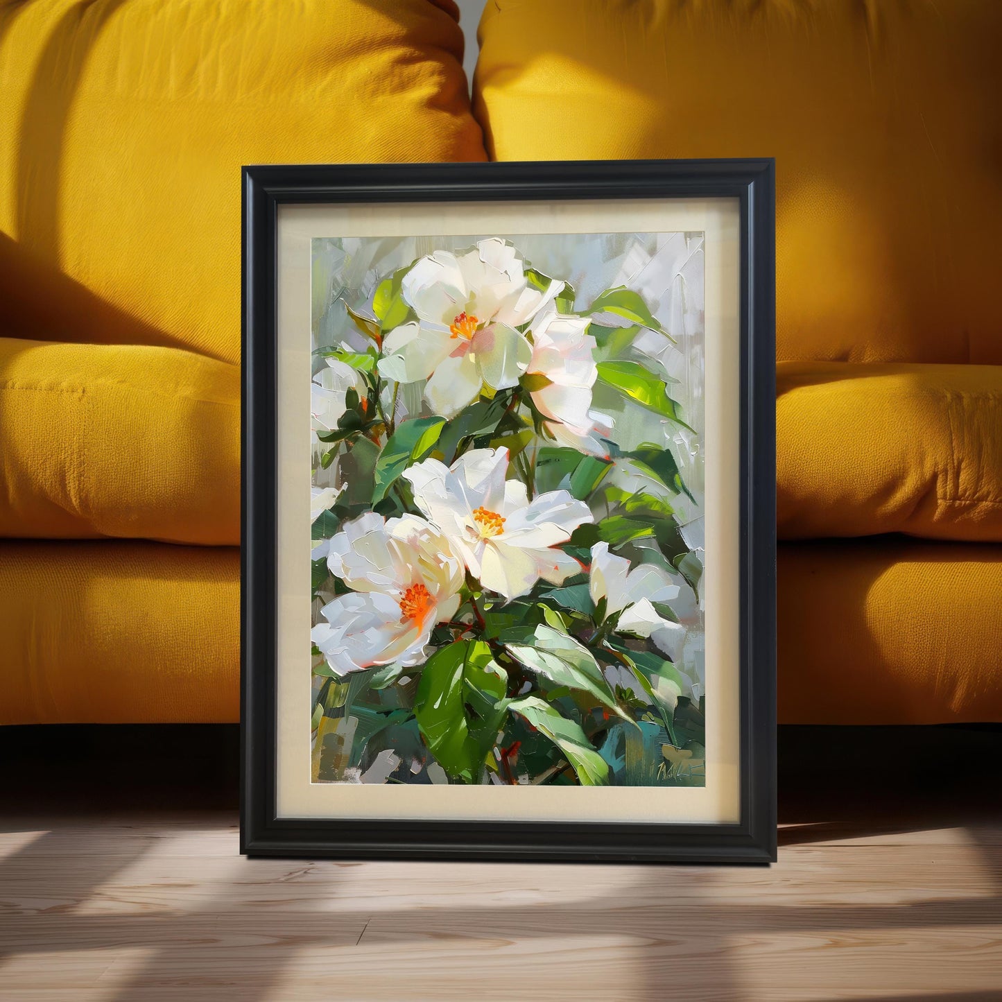 Black framed oil painting print of white flowers with vibrant orange centers and green leaves, with a mount. Leaning on the floor against a bright yellow couch.