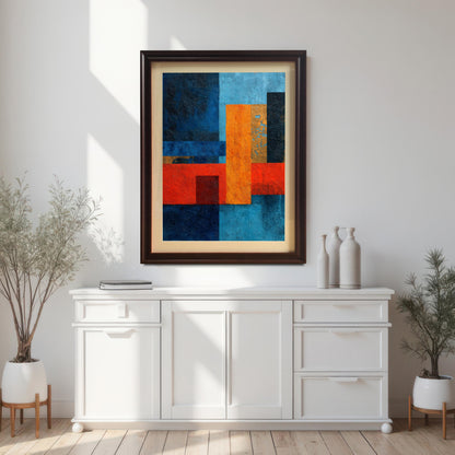 Abstract geometric art print framed in dark Coffee wood with a light mount, hanging on a bright white wall above a long white console table with decorative vases and plants.