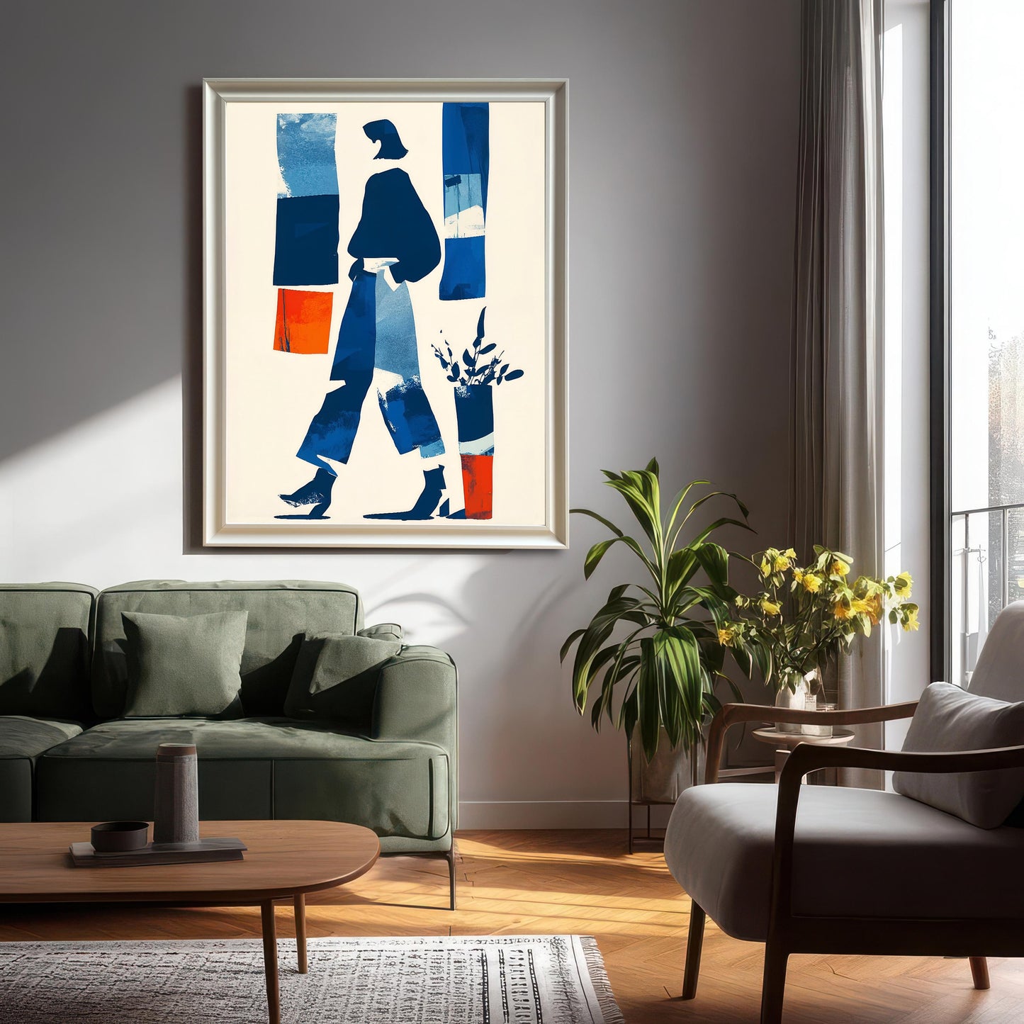 Large framed abstract art print in a white/light frame hanging above a dark green sofa in a modern living room setting with natural light and house plants.