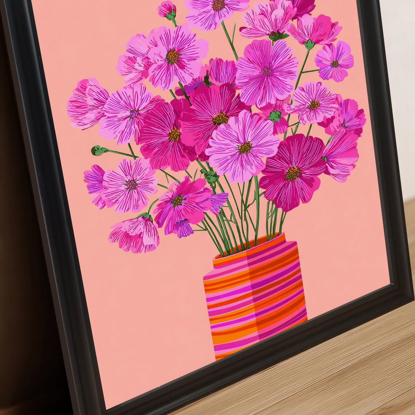 Extreme close-up of the bright pink Cosmos flower print in a black frame, emphasizing the floral detail and the colorful striped vase.