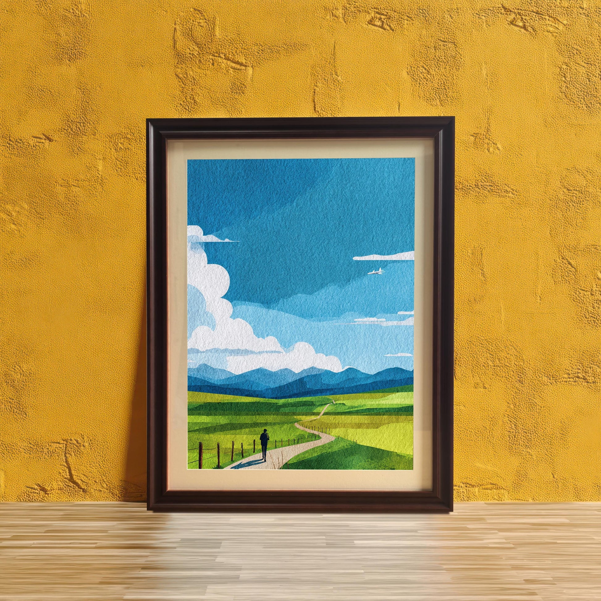 Abstract landscape print featuring a bright blue sky, green fields, and a person walking on a path, in a Coffee (dark brown) frame with a mount. The print is displayed leaning on a light wooden surface against a vibrant yellow textured wall.