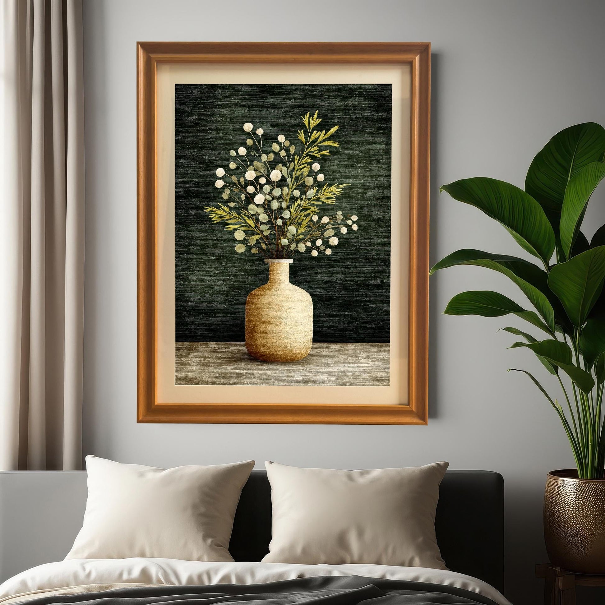 A framed art print of a vase with green and white foliage, displayed above a bed with cream pillows and gray bedding. The frame is Orange/Brown wood. A large green houseplant is visible on the right.