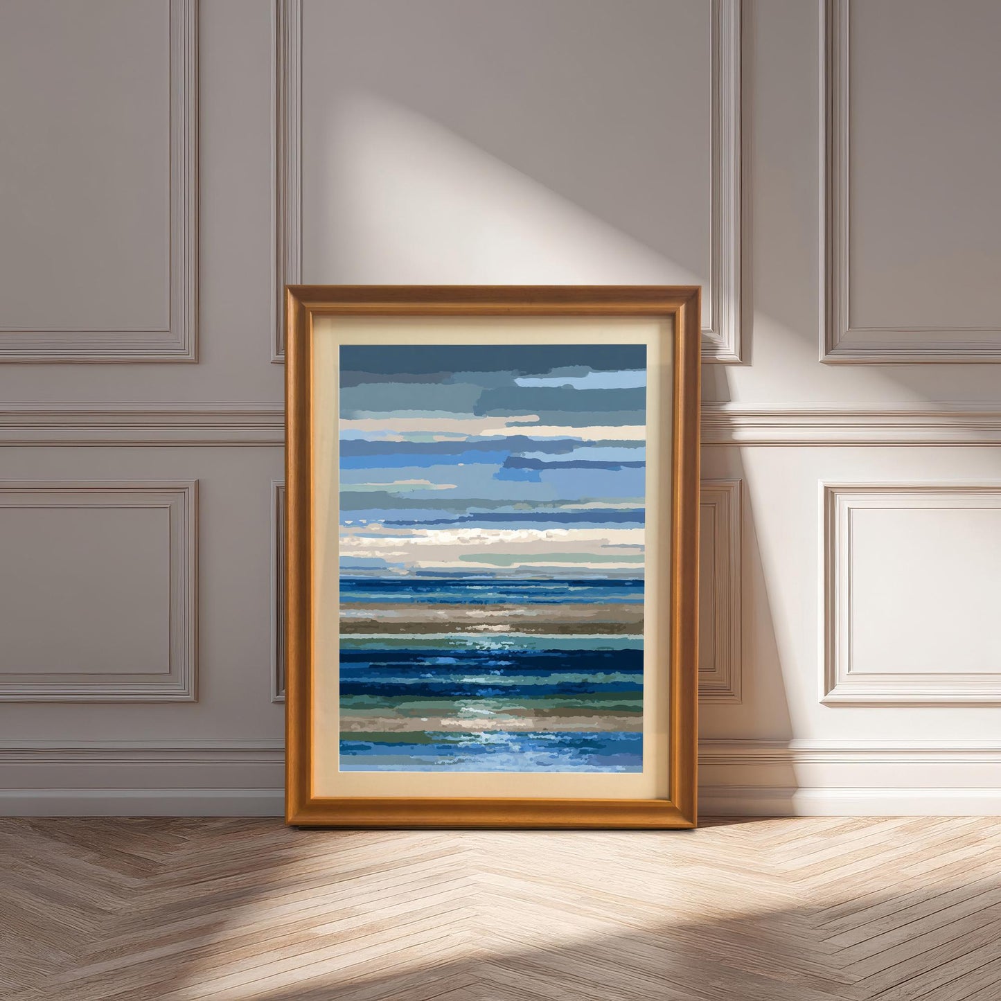 Abstract blue and brown striped seascape print in a gold/orange wood frame with a mount, leaning against a white paneled wall on a wood floor, with sunlight casting shadows.
