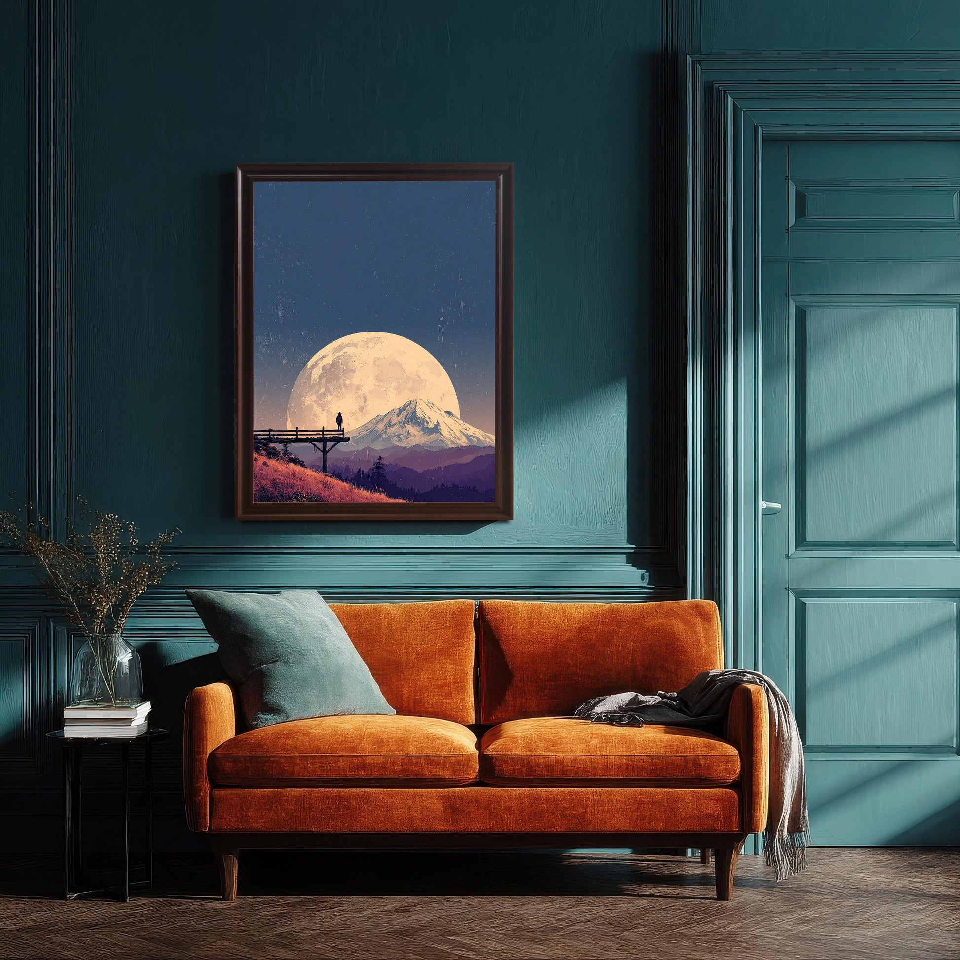 Large landscape art print in a dark wood frame, hanging above an orange velvet sofa against a dark teal paneled wall.