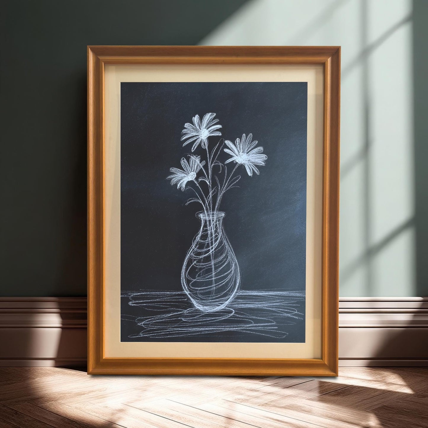 A full shot of the chalk flower print in an orange/light brown wooden frame with a mat, leaning on the floor against a dark green wall, illuminated by a strip of sunlight.