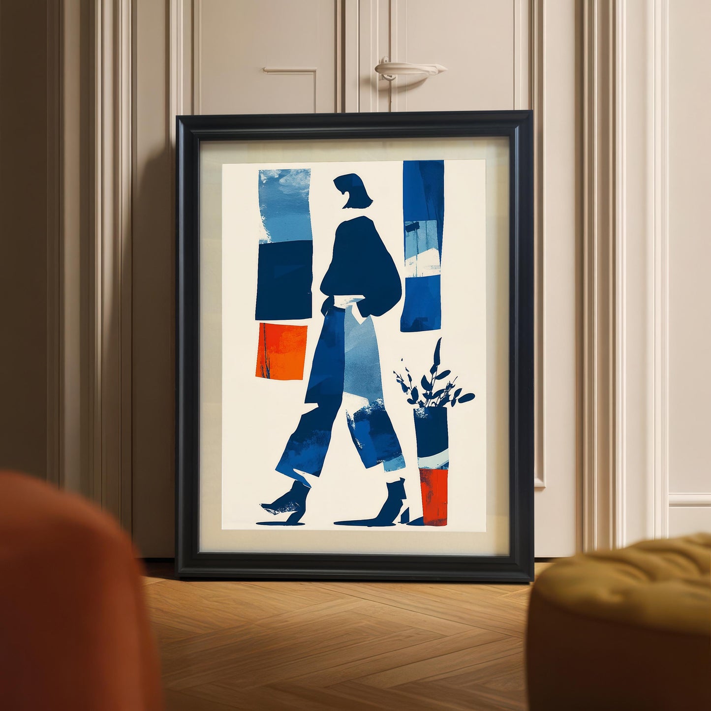 Framed abstract art print in a black wooden frame leaning on a light hardwood floor against a white door, with the focus on the artwork and frame details.