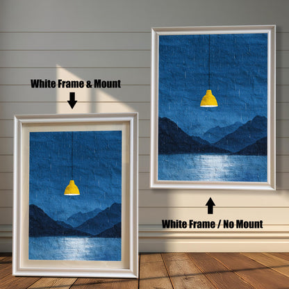 A comparison image showing two framed art prints on a wooden wall. The print on the left is in a White Frame & Mount (white frame with a light mat). The print on the right is in a White Frame / No Mount (white frame, no mat). Both feature the dark blue rainy landscape with the yellow lamp.