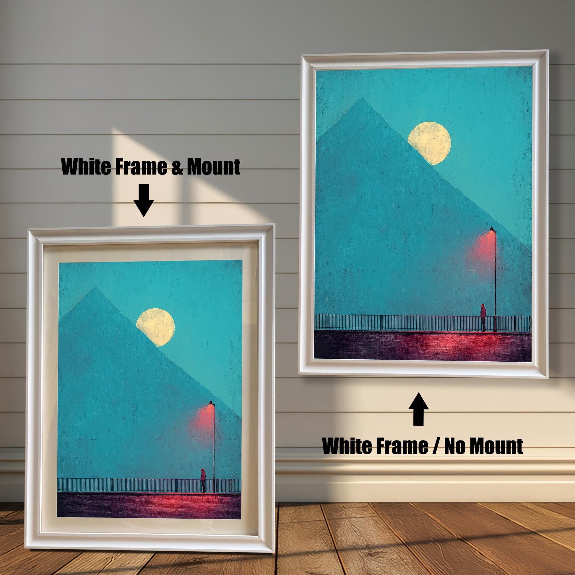 Comparison image showing two framed art prints against a white wainscoting wall. The left print uses a White Frame & Mount (matting). The right print uses a White Frame / No Mount. The art depicts a minimal landscape with a figure, a red lamp post, and a pyramid under a moon.