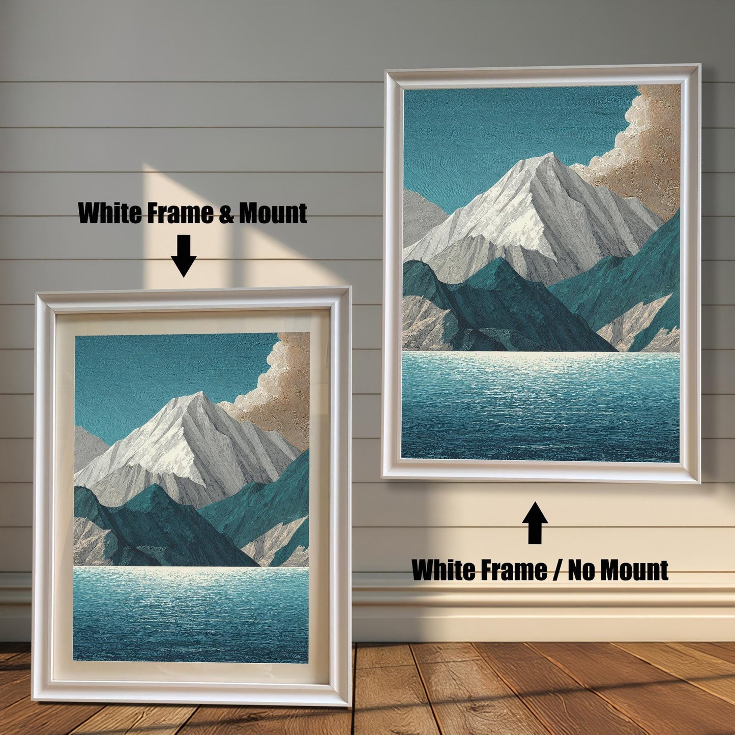 A comparison image showing two framed art prints on a wooden wall. The print on the left is in a White Frame & Mount (white frame with a light mat). The print on the right is in a White Frame / No Mount (white frame, no mat). Both feature the mountain and lake design.