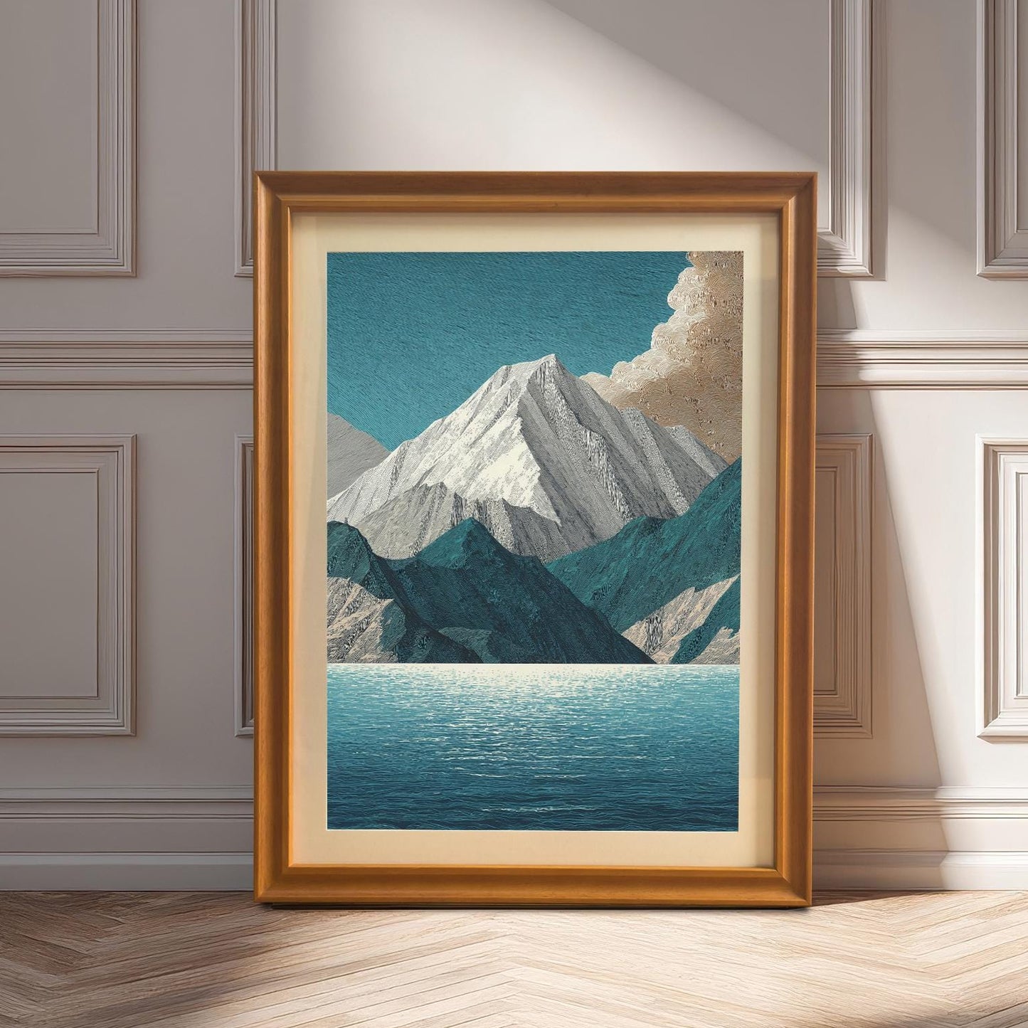 A framed art print of the mountain and lake design in an Orange (golden/bronze) frame with a mount, leaning against a white wainscoting wall on a herringbone floor. Sunlight creates deep shadows.