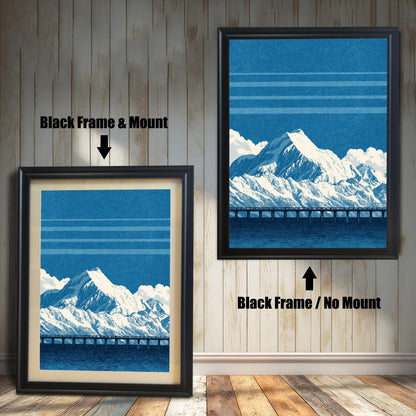 A comparison image showing two framed art prints on a wooden wall. The print on the left is in a Black Frame & Mount (black frame with a light mat). The print on the right is in a Black Frame / No Mount (black frame, no mat). Both feature the blue mountain and bridge design.