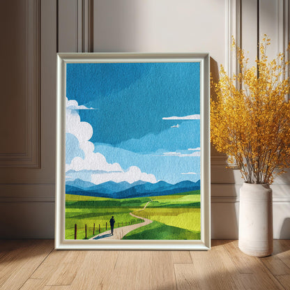 Framed art print of a colorful green and blue landscape with a figure on a path, in a White frame. The print is leaning on a wooden floor against a white paneled wainscoting wall, beside a tall white vase with bright yellow dried flowers.