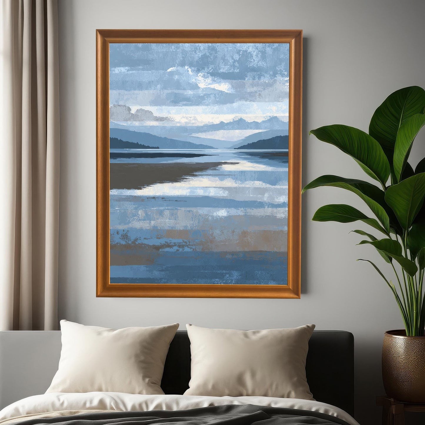 Abstract landscape art print in an Orange wood frame, hanging on a gray wall above a bed with pillows, next to a large potted plant.
