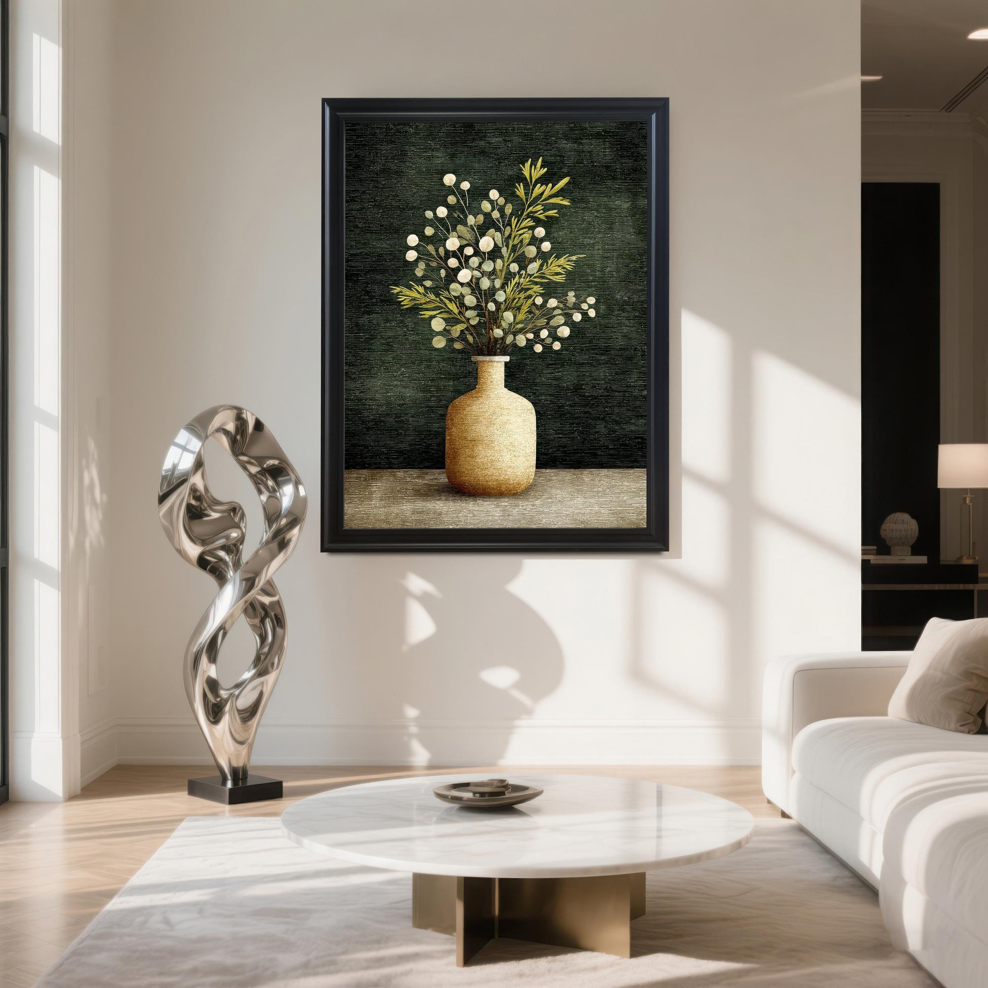 A large framed art print of a vase with green and white foliage, hanging on a white wall in a modern living room. The frame is Black. Below the print are a marble coffee table and a silver abstract sculpture.