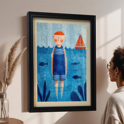 A woman with glasses is admiring a framed nautical art print hanging on a pale wall. The print features a person in a blue and white striped swimsuit standing in the water with a sailboat nearby, framed in black with a white mount. Dried wheat stalks are visible in a vase to the left.