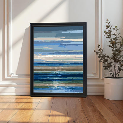 Abstract blue and brown striped seascape art print in a simple black frame, leaning on a wooden floor against a white paneled wall next to a potted plant, with long shadows from sunlight.