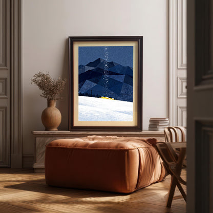 Framed art print with dark blue geometric mountains, a snowy slope, and a trail of stars, displayed on a marble console above a brown leather ottoman in a sunlit living room.
