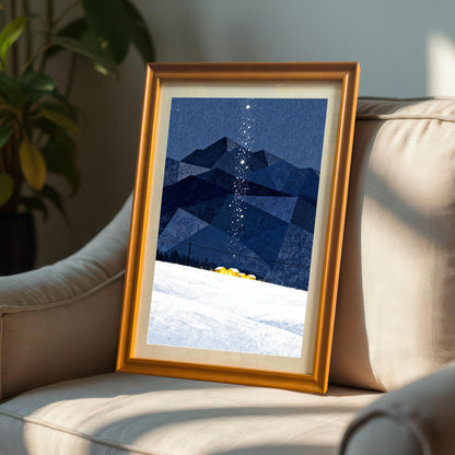 Framed art print in an Orange Frame with a mount, featuring dark blue geometric mountains, snow, and a starry trail, resting on a beige armchair indoors with a plant visible in the background.