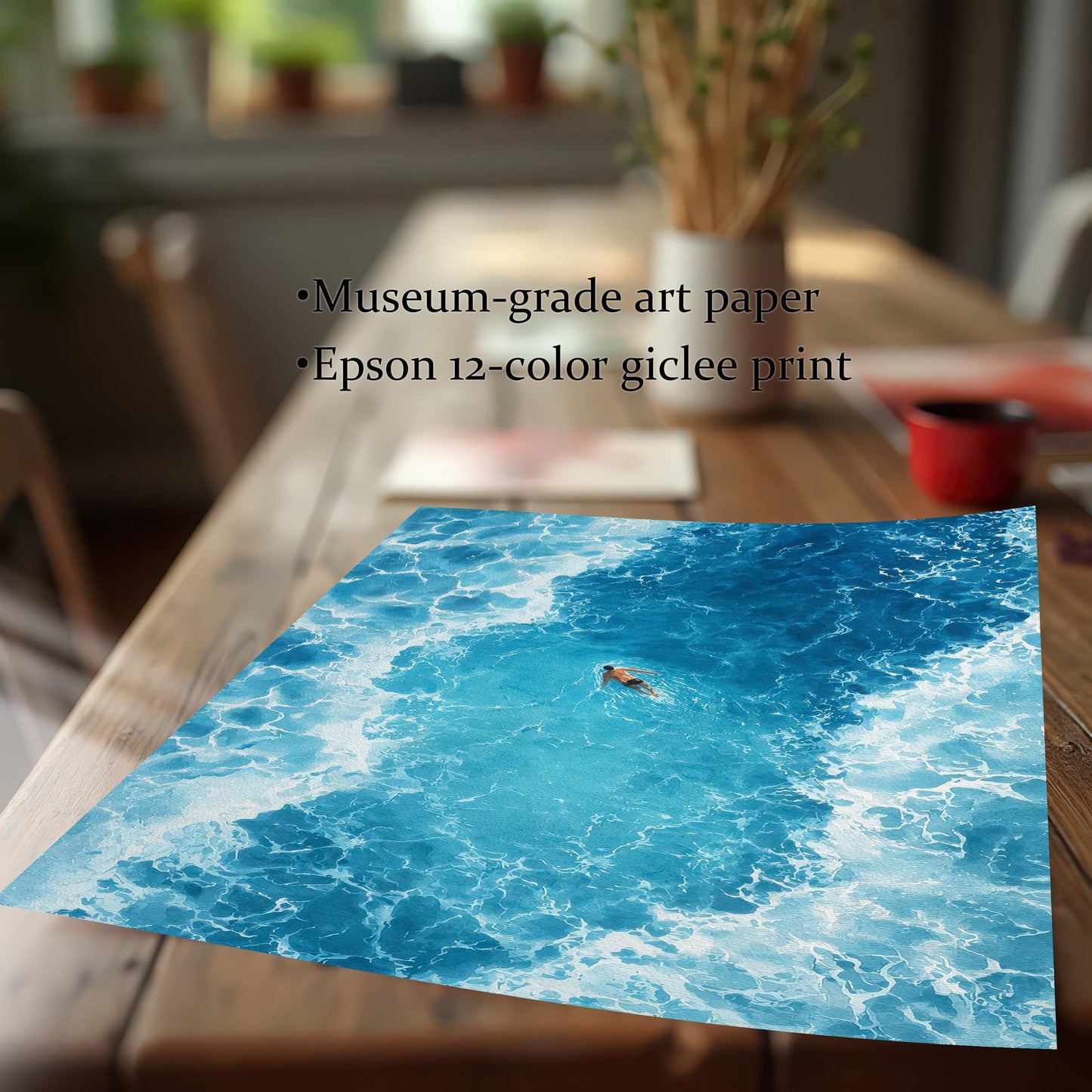 Close-up of the ocean art print, showing an overhead view of a swimmer in bright blue water surrounded by white foam. Text overlay highlights product features: Museum-grade art paper, Epson 12-color giclee print.