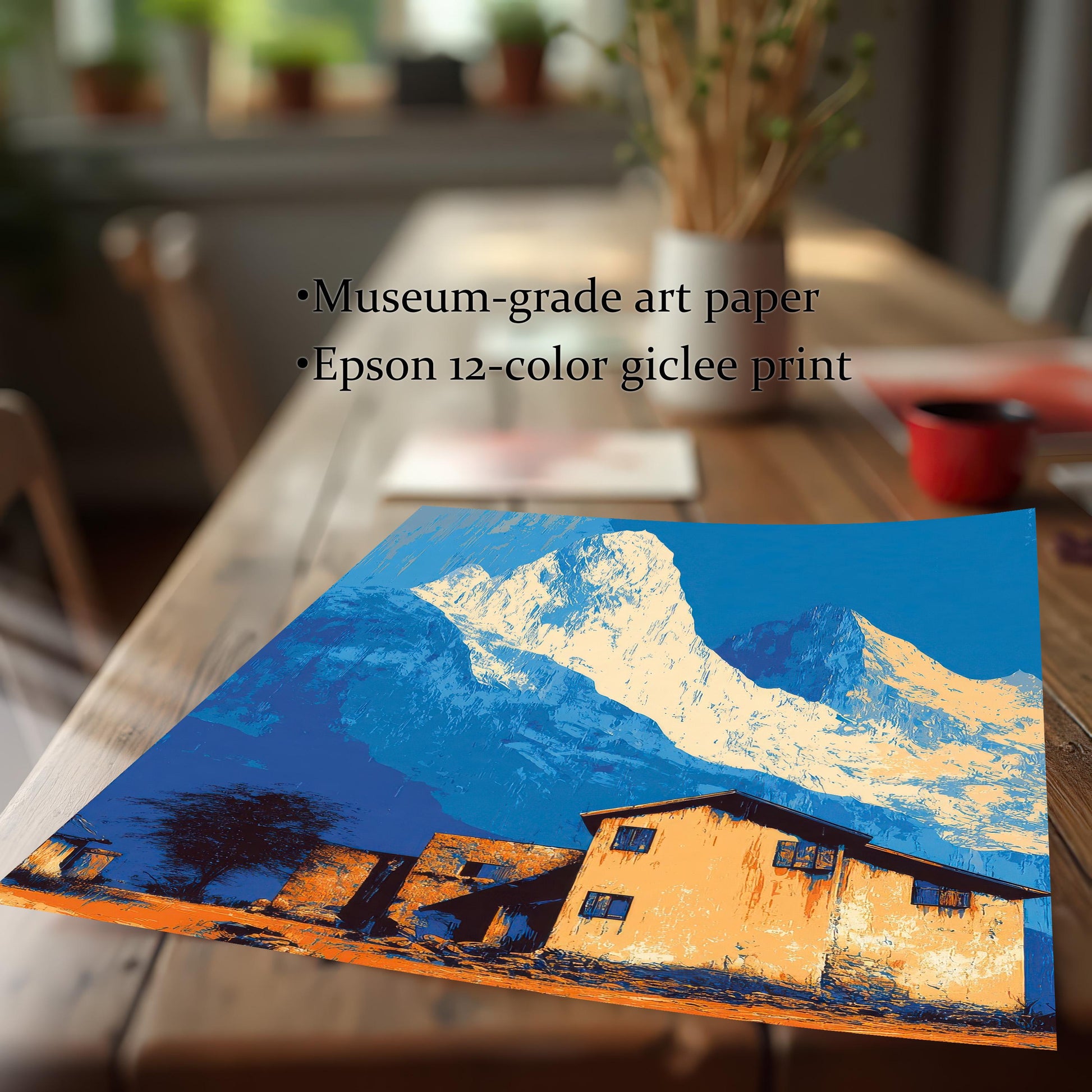 Close-up of the landscape art print lying on a wooden table, featuring bright blue and orange colors, and noting ""Museum-grade art paper"" and ""Epson 12-color giclee print.""