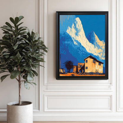 Large landscape art print in a black frame, featuring stylized blue and white mountains and an orange house, hanging on a white decorative wall next to a tall potted plant.