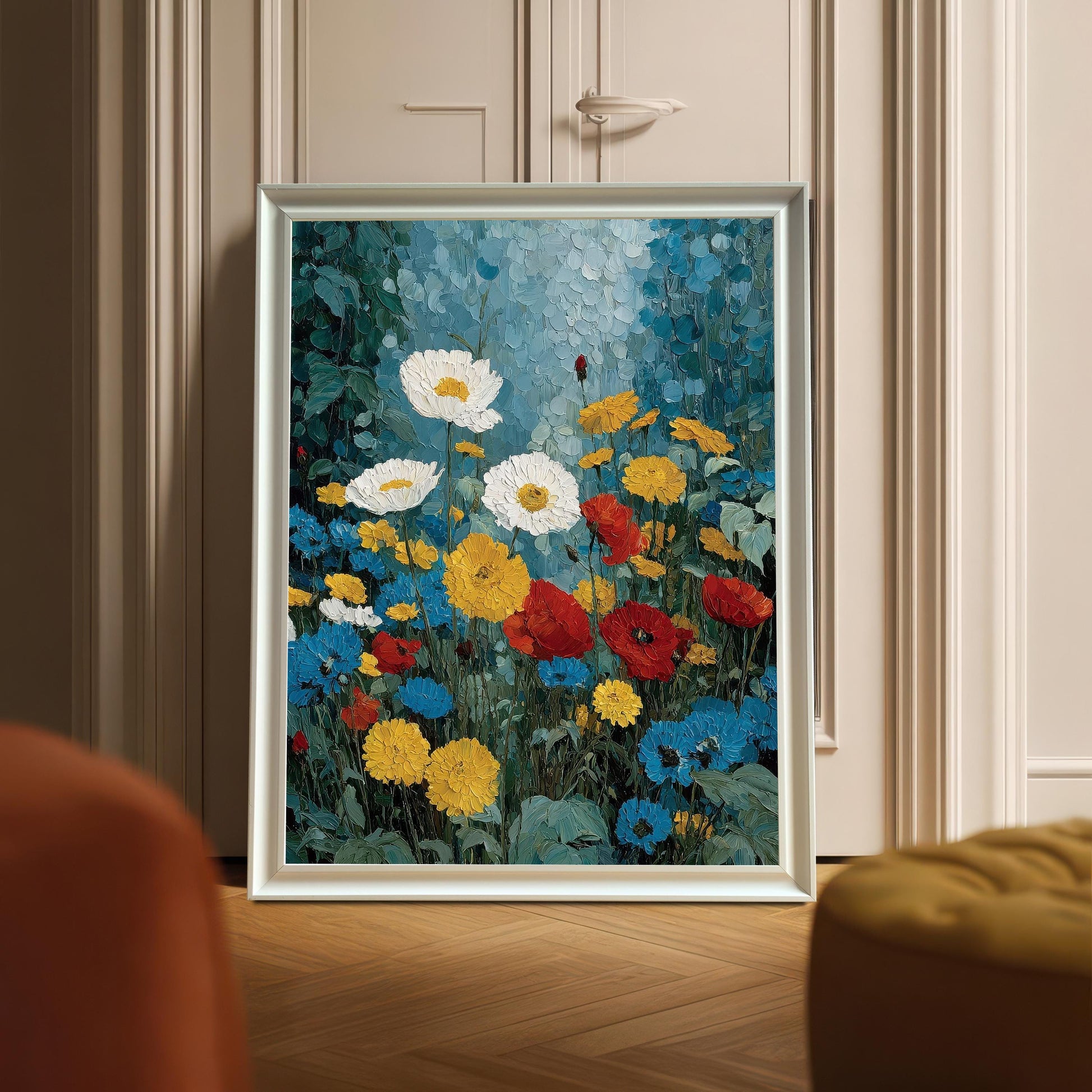 A white-framed floral art print leaning against an elegant interior door on a herringbone wood floor. The scene is shot from a low angle with soft, warm lighting.
