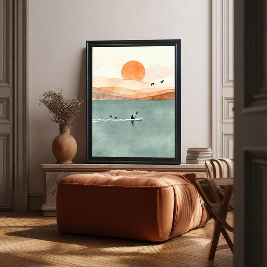 Minimalist watercolor landscape of a kayaker at sunset in a black wood frame leaning on a console table in a modern living room.