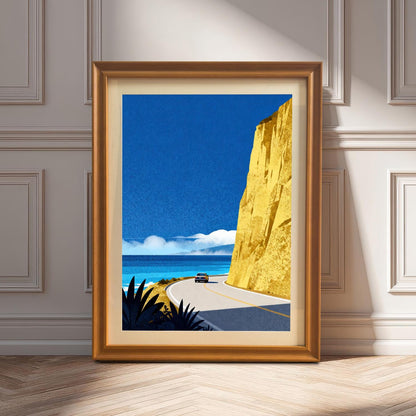 An orange-toned wood-framed art print with a cream mount leaning on a light-colored wooden floor against a classic paneled wall in sunlight.