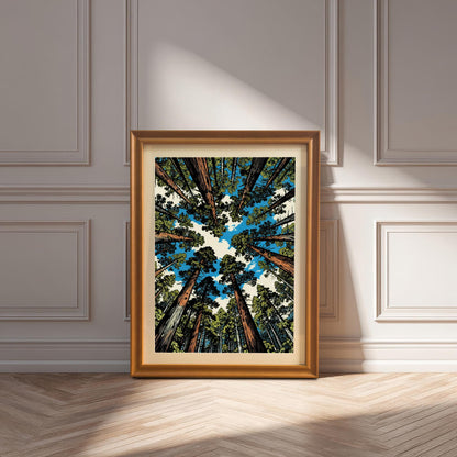 Large orange wood framed redwood tree art print with a white mount, resting on a herringbone wood floor in a bright, sunlit room.