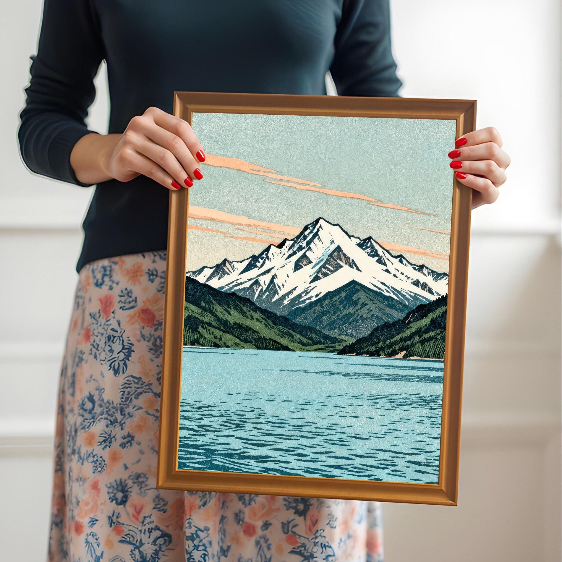 A person holding a medium-sized orange wood framed mountain print to provide a real-world scale and size reference.
