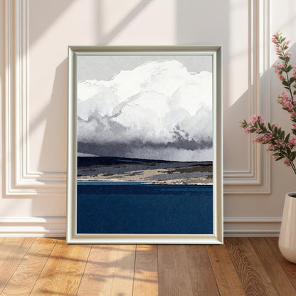 A white wood-framed art print leaning against a classic white wainscoted wall on a light oak wood floor, positioned next to a white ceramic vase with pink flowers in soft, natural sunlight.