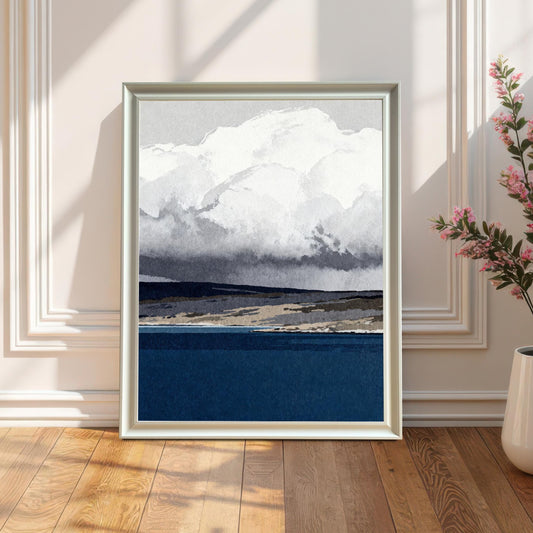 A white wood-framed art print leaning against a classic white wainscoted wall on a light oak wood floor, positioned next to a white ceramic vase with pink flowers in soft, natural sunlight.