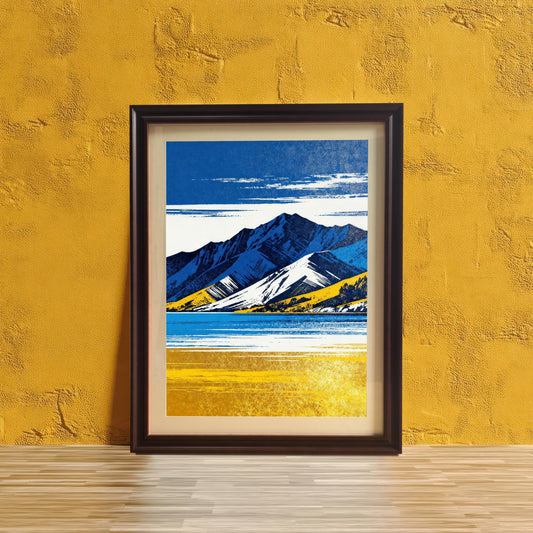 A framed art print in a dark brown/black frame with a light mount, featuring the blue and yellow mountain landscape, standing on a light wooden floor against a vibrant textured yellow wall.
